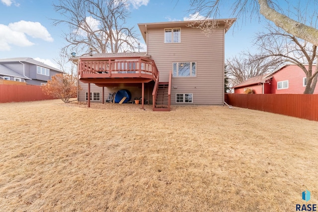 back of property featuring a wooden deck and a yard