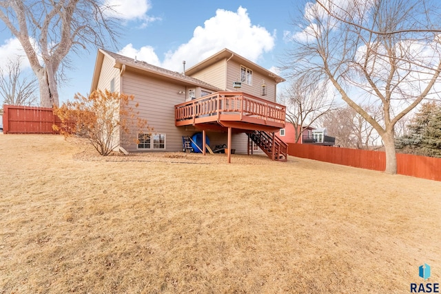 back of house featuring a wooden deck and a yard