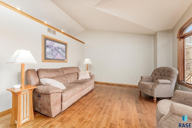 living room featuring vaulted ceiling and light wood-type flooring