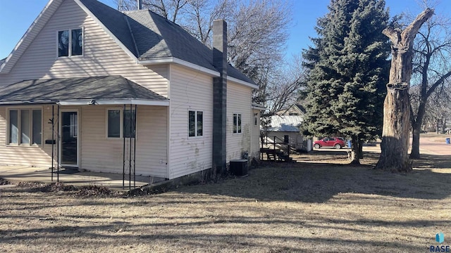 view of side of home with a yard and central air condition unit