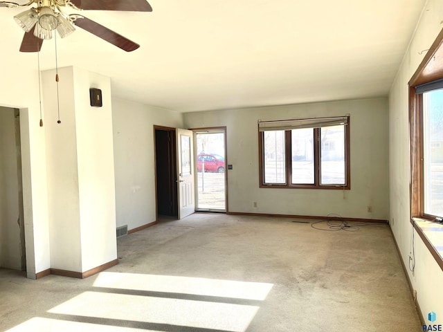 empty room featuring ceiling fan and light colored carpet