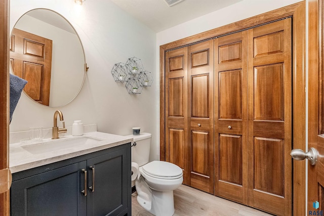 bathroom featuring hardwood / wood-style flooring, vanity, and toilet