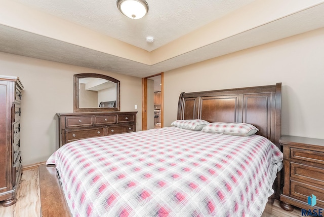 bedroom with a textured ceiling and light wood-type flooring