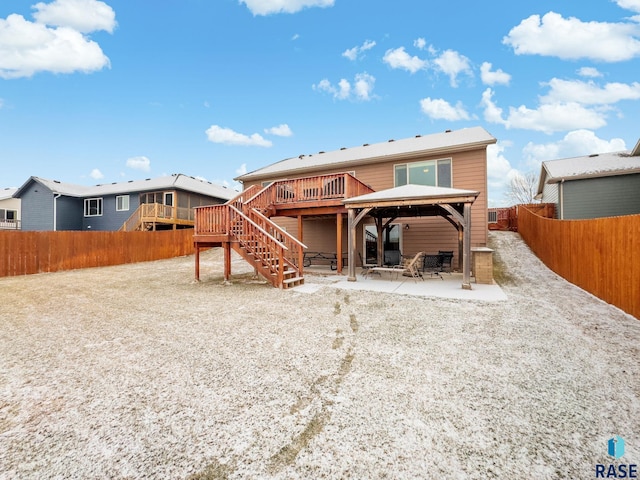 rear view of property with a gazebo, a wooden deck, and a patio area