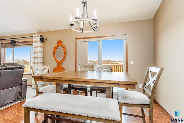 dining area featuring a notable chandelier and light wood-type flooring