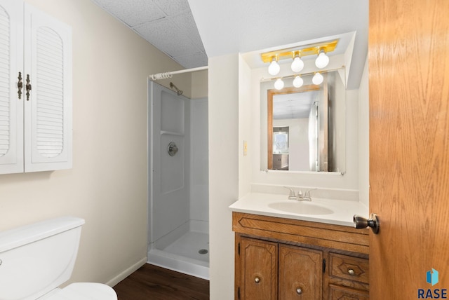 bathroom featuring toilet, wood-type flooring, vanity, and walk in shower