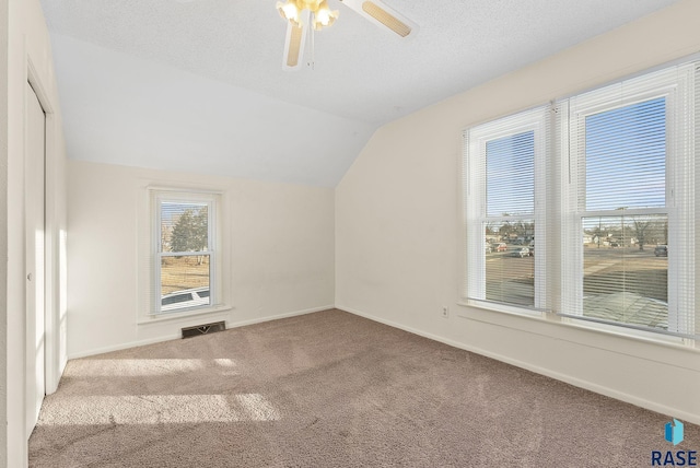 bonus room with lofted ceiling, ceiling fan, a textured ceiling, and carpet flooring