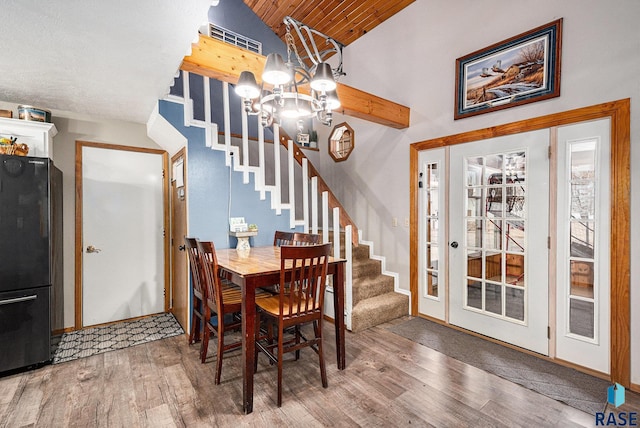 dining space with wood ceiling, wood-type flooring, a chandelier, and vaulted ceiling