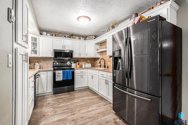 kitchen featuring sink, white cabinets, refrigerator with ice dispenser, light wood-type flooring, and electric stove