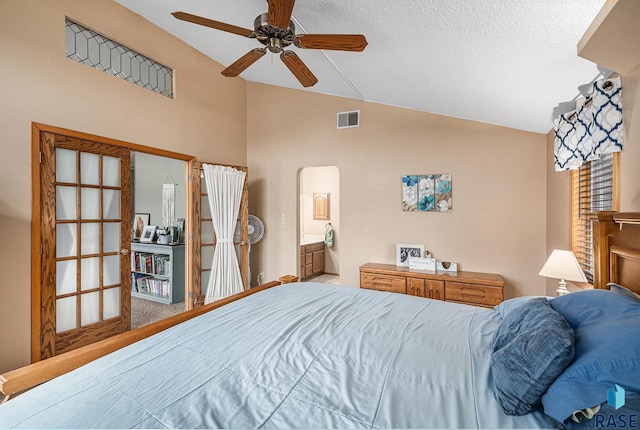 bedroom with ceiling fan, ensuite bath, vaulted ceiling, and a textured ceiling