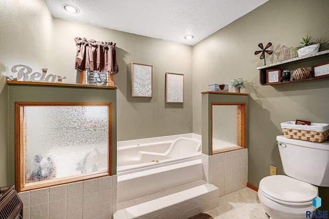 bathroom featuring tiled bath, a textured ceiling, and toilet