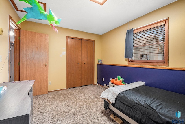 bedroom with multiple windows, light colored carpet, and a closet