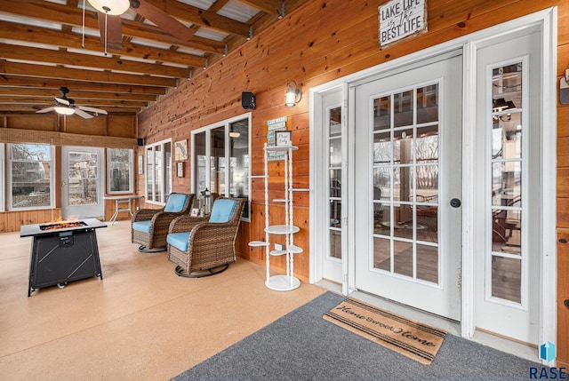 sunroom / solarium featuring beam ceiling and ceiling fan