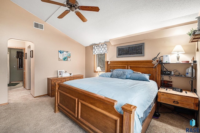 carpeted bedroom with ceiling fan, vaulted ceiling, and a textured ceiling