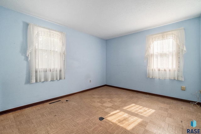 empty room featuring a textured ceiling and light parquet floors