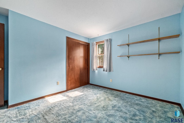 unfurnished bedroom with carpet floors, a closet, and a textured ceiling