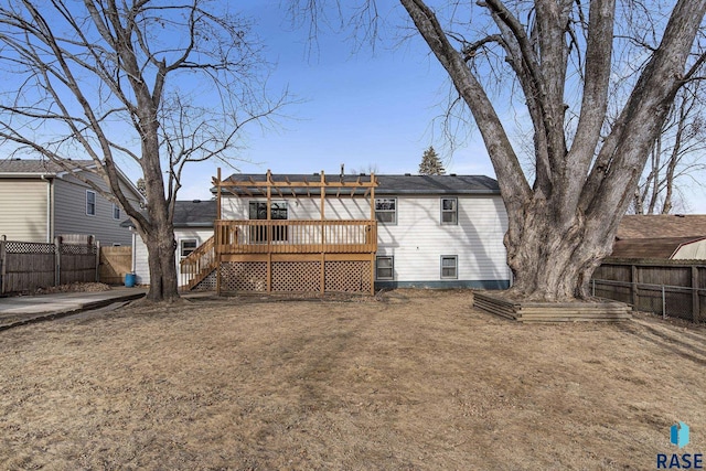 rear view of house featuring a wooden deck and a yard