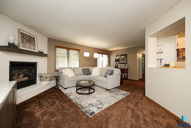 living room featuring a fireplace, a textured ceiling, and dark colored carpet