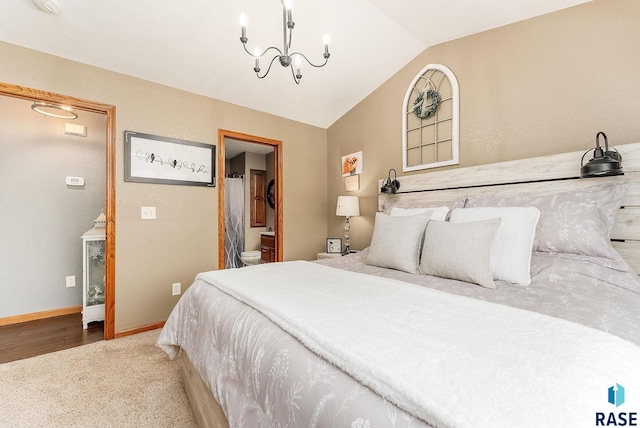 bedroom featuring vaulted ceiling, connected bathroom, and a notable chandelier