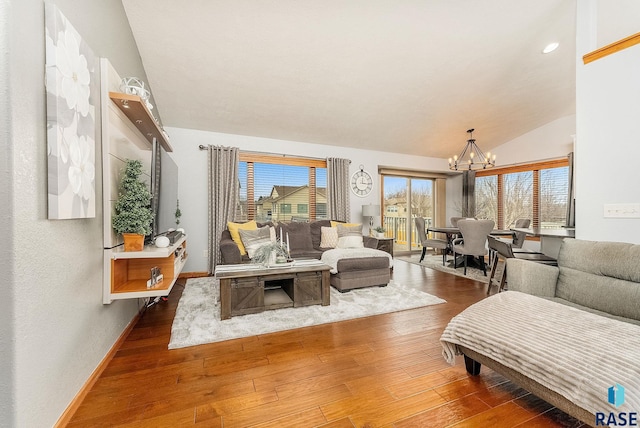 living room with an inviting chandelier, wood-type flooring, and vaulted ceiling