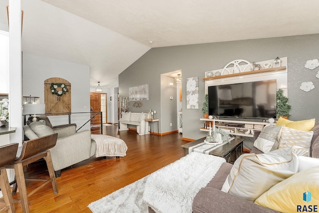 living room with hardwood / wood-style flooring and vaulted ceiling