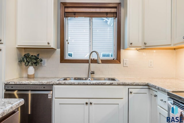 kitchen featuring dishwasher, sink, light stone countertops, and white cabinets