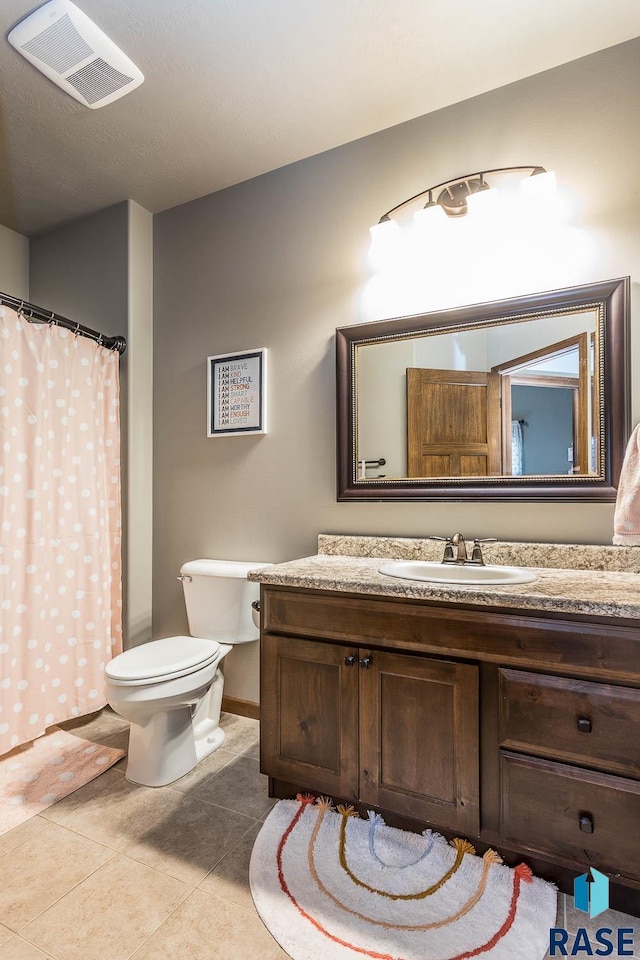 bathroom with vanity, tile patterned flooring, and toilet