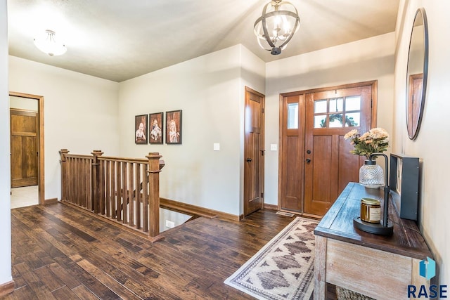 foyer entrance featuring dark hardwood / wood-style floors and a chandelier