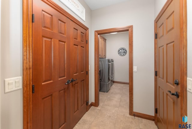 hallway featuring washer and dryer and light tile patterned flooring