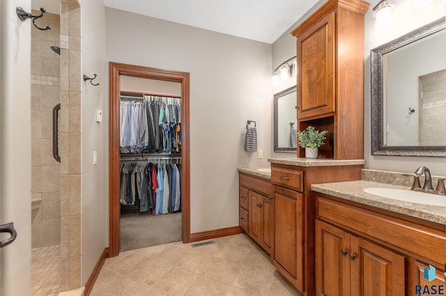 bathroom with tile patterned flooring, vanity, and a shower with shower door