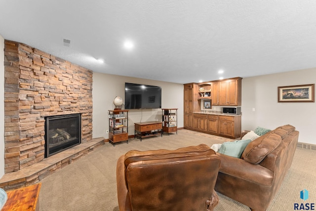 carpeted living room with a textured ceiling and a fireplace