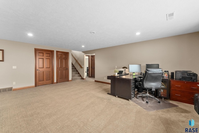 office featuring light colored carpet and a textured ceiling