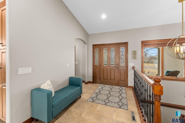 tiled entrance foyer featuring lofted ceiling and a notable chandelier