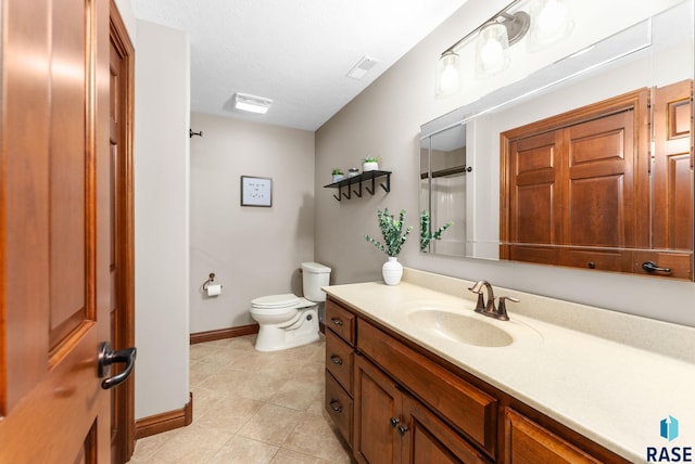 bathroom featuring tile patterned flooring, vanity, and toilet