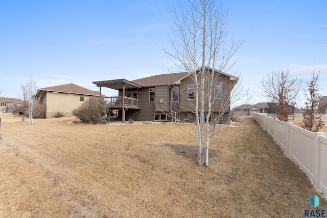 rear view of property featuring a deck and a lawn