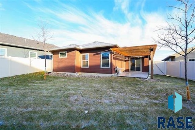 rear view of property with a pergola, a patio area, and a lawn