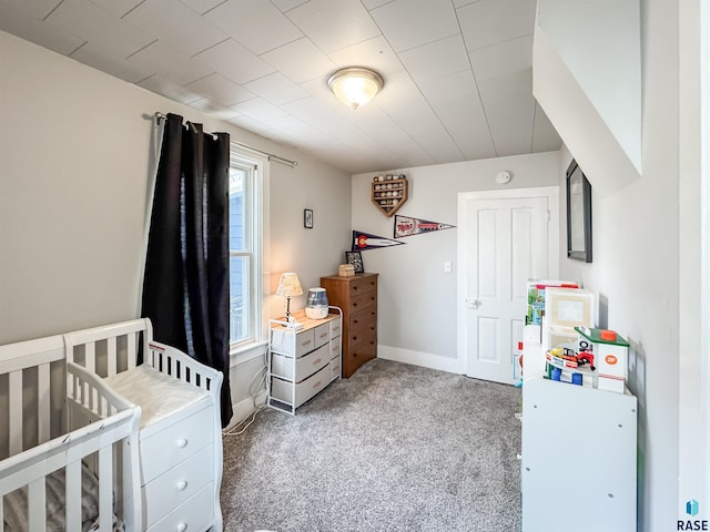 carpeted bedroom with a nursery area