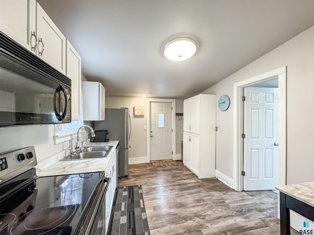 kitchen featuring sink, hardwood / wood-style floors, white cabinets, and stainless steel range with electric stovetop