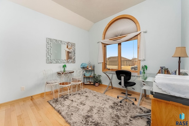 home office featuring vaulted ceiling and hardwood / wood-style floors