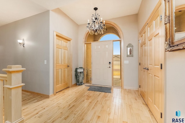 entryway with light hardwood / wood-style floors and a chandelier