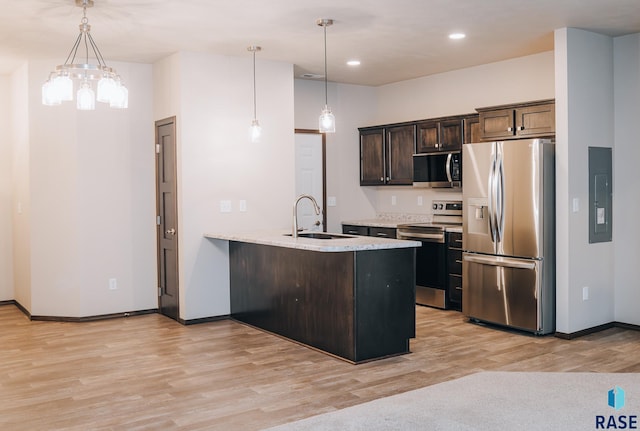 kitchen featuring dark brown cabinetry, sink, decorative light fixtures, appliances with stainless steel finishes, and kitchen peninsula