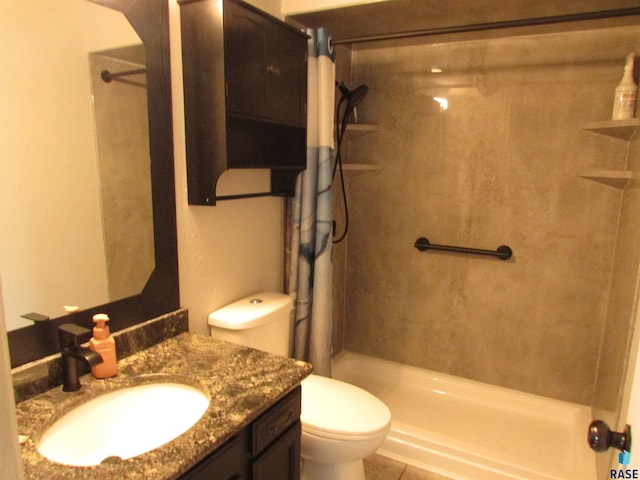 bathroom featuring vanity, a tile shower, and toilet