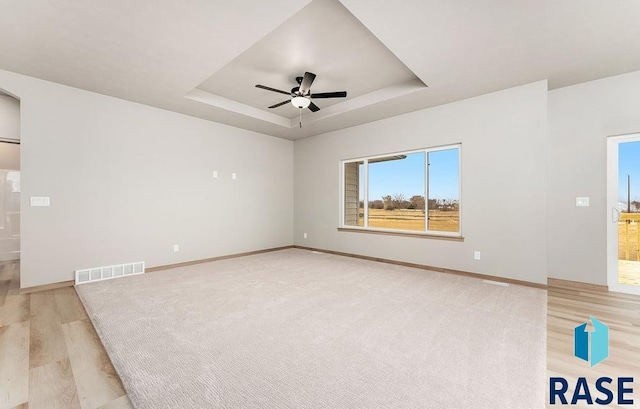 1004 N Juniper St, Lennox, SD 57039 - unfurnished room with ceiling fan, a raised ceiling, and light hardwood / wood-style flooring