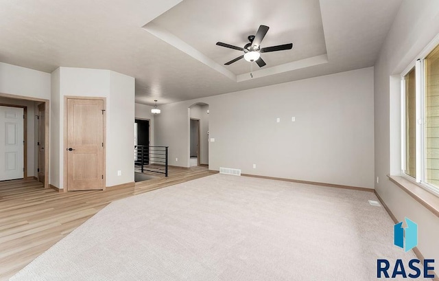 1004 N Juniper St, Lennox, SD 57039 - living room with a tray ceiling, light hardwood / wood-style floors, and ceiling fan