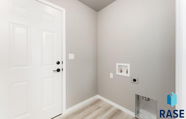 clothes washing area with hookup for a washing machine, electric dryer hookup, and light hardwood / wood-style flooring