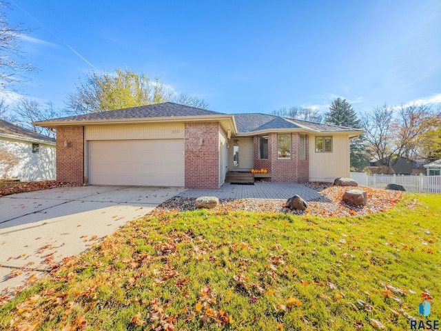 ranch-style home with a garage and a front lawn