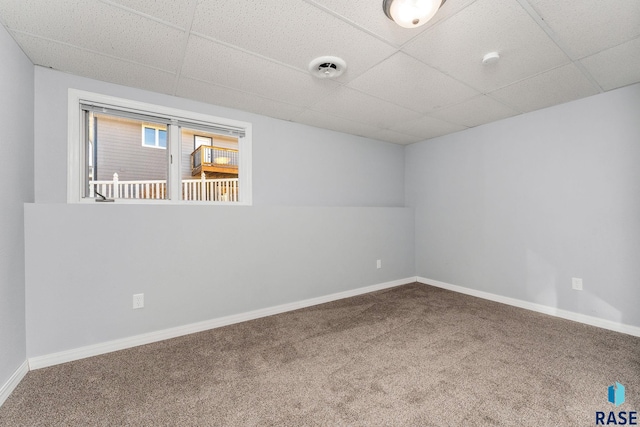 unfurnished room featuring a paneled ceiling and carpet floors