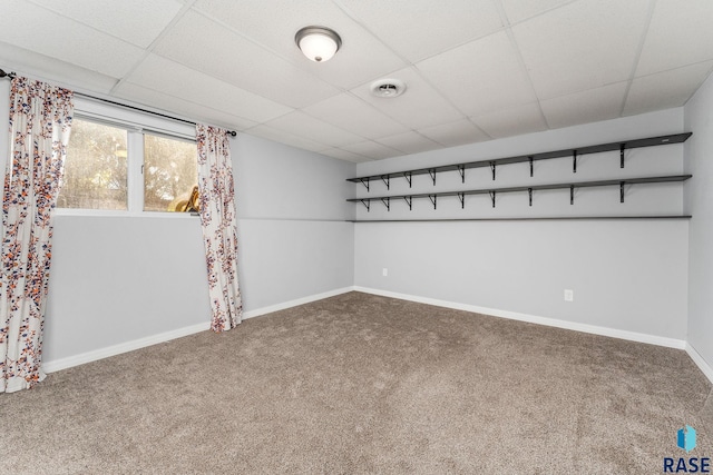 basement with carpet floors and a paneled ceiling