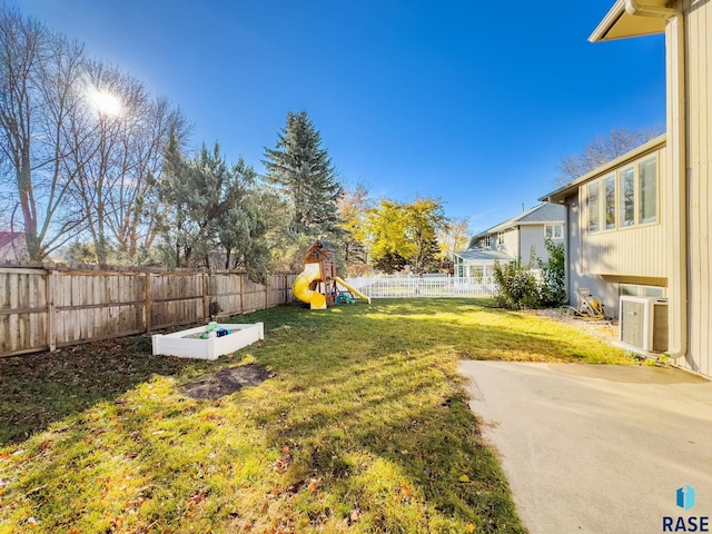 view of yard featuring a playground, a patio, and ac unit