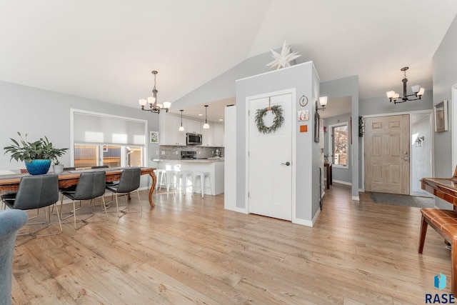 kitchen with white cabinetry, a notable chandelier, light hardwood / wood-style floors, and hanging light fixtures